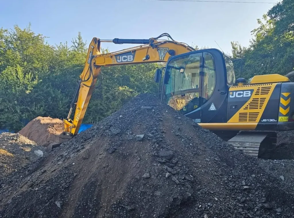a yellow construction vehicle with a pile of dirt
