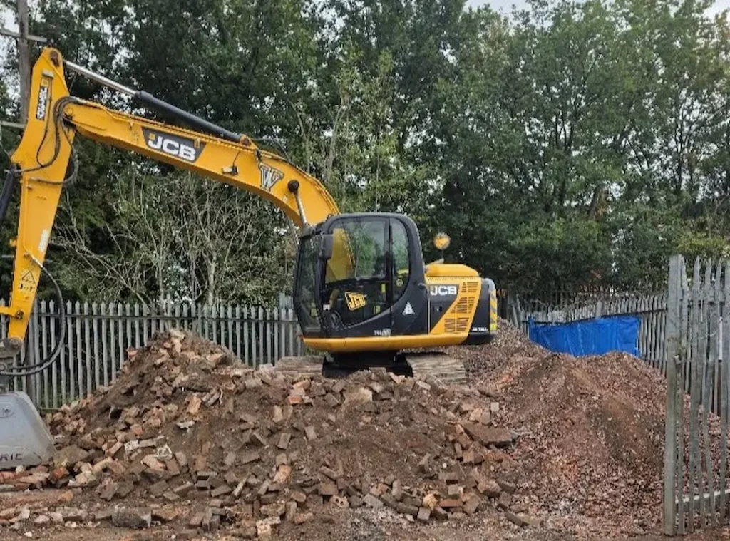 a yellow construction vehicle with a pile of rubble