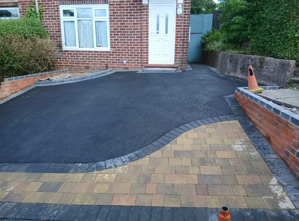 a driveway with brick and concrete